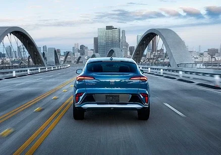 Blue 2026 Buick Envista driving on a city bridge