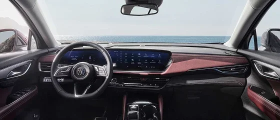 Interior of the 2026 Buick Envision with red trim, showing the steering wheel and the ultrawide dashboard display