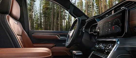 Interior of the 2026 GMC Sierra 1500 showing tan leather seats, the steering wheel and the dashboard touchscreen