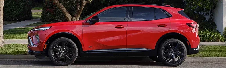 Side profile of a red Buick Envision with black alloy wheels parked at a suburban kerb