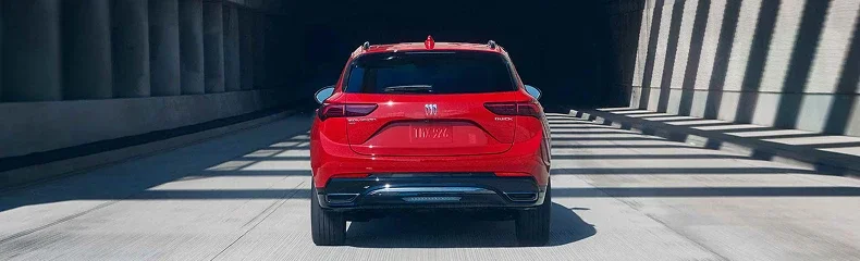 Rear view of a red Buick Envision in a sunlit concrete underpass