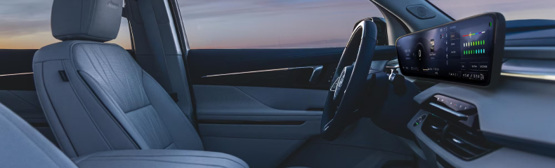 Buick Enclave front seats in quilted gray leather beside the ultrawide curved dashboard screen