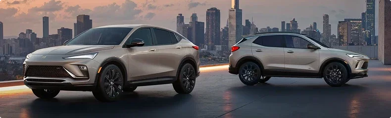 Two beige Buick Envista SUVs parked on a rooftop with a city skyline behind them