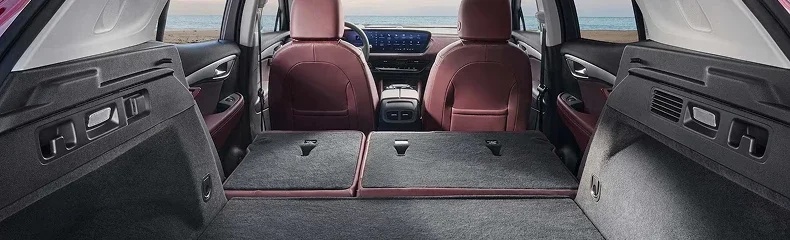 Envision cargo area with the rear seats folded flat, looking forward to red leather front seats
